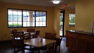 un comedor con mesas, sillas y ventanas en Rodeway Inn Joint Base Andrews Area, en Camp Springs