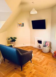 sala de estar con sofá azul y TV en Beautiful One Bed Apartment in West End Folkestone, en Kent