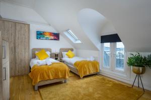 a bedroom with two beds with yellow pillows at The Clarendon in Dundee