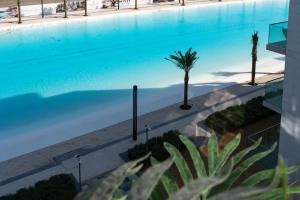 einen Blick über einen großen Pool mit Palmen in der Unterkunft Dar Alsalam - Modern Comforts in Dubai District One Residence 29 in Dubai