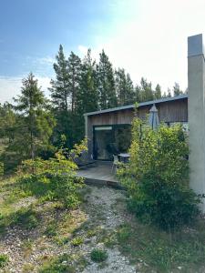 un edificio con porche, mesa y sillas en Maven Kustnära Stugor, en Kappelshamn
