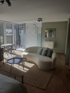 ein Wohnzimmer mit einem weißen Sofa und einem Tisch in der Unterkunft Home Away in Blankenberge