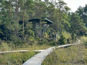 a house in the woods with a wooden bridge at Maven Kustnära Stugor in Kappelshamn