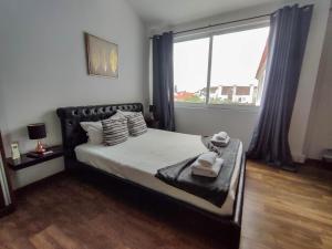 a bedroom with a bed and a large window at Vintage Place - Azorean Guest House in Ponta Delgada
