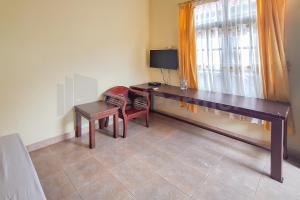 a room with a desk and a chair and a window at Aman Guest House Redpartner in Palangkaraya