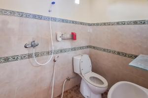 a bathroom with a toilet and a shower at Aman Guest House Redpartner in Palangkaraya +8 photos