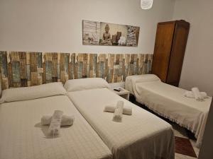 ein Zimmer mit 2 Betten mit Kreuzen in der Unterkunft Pension Hidalgo 1 in Utrera