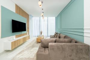 sala de estar con sofá y TV de pantalla plana en Dar Alsalam - Modern Comforts in Dubai District One Residence 29, en Dubái