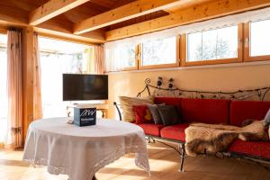 - un salon avec un canapé rouge et une table dans l'établissement Ferienhaus Casa Chapf, à Amden