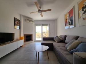 Una sala de estar con un sofá y un televisor. en Calahonda Royale Penthouse with Sea Views, en Cabopino