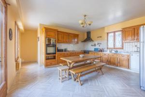 a kitchen with wooden cabinets and a wooden table at Les Grandes Landes - Piscine privée - Grand jardin in Cricqueville-en-Bessin
