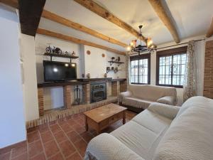 a living room with a couch and a tv at LA CUADRA in Gaucín