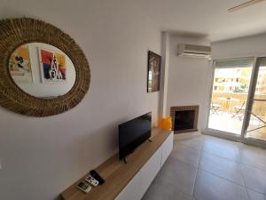 Una sala de estar con televisión y un espejo. en Calahonda Royale Penthouse with Sea Views, en Cabopino