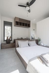 a bedroom with two beds and a ceiling fan at NIMA Suites in Paleros +59 photos