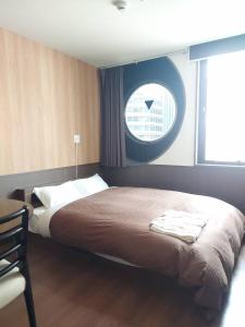 1 dormitorio con 1 cama grande y ventana en Hotel Ekichika Nagahoribashi, en Osaka