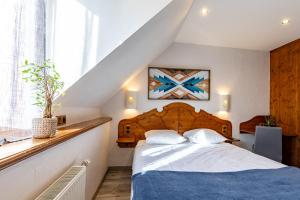 - une chambre avec un lit doté d'une tête de lit en bois dans l'établissement Auberge de la Rivière, à Foncine-le-Haut