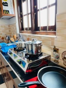 a stove with pots and pans on top of it in a kitchen at 682 Villa Weligama in Weligama