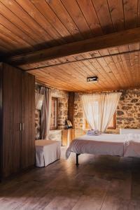 a bedroom with two beds and a wooden ceiling at Petradi Guesthouse in Synikia Mesi Trikalon