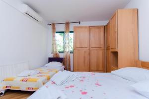 a bedroom with two beds and a closet at Apartments Zdenka in Lopar