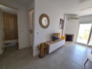 Una sala de estar con un televisor y un espejo en la pared. en Calahonda Royale Penthouse with Sea Views, en Cabopino