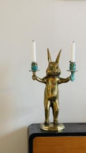 a gold statue of a rabbit holding two candles at ApartmentInCopenhagen Apartment 1593 in Copenhagen