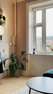 a living room with a table and a window at ApartmentInCopenhagen Apartment 1593 in Copenhagen