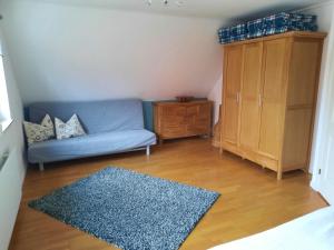 salon z niebieską kanapą i drewnianą podłogą w obiekcie Ferienhaus-Landliebe-Wohnung-9048-3 w mieście Dänschendorf