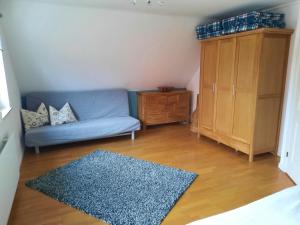 ein Wohnzimmer mit einem blauen Sofa und Holzboden in der Unterkunft Ferienhaus Landliebe, Wohnung 9048-3 in Dänschendorf