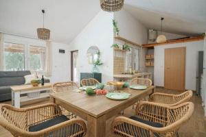 a kitchen and living room with a wooden table and chairs at Villa Ivana Whisper of nature in Vodice