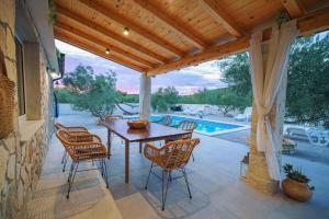 a patio with a table and chairs and a pool at Villa Ivana Whisper of nature in Vodice
