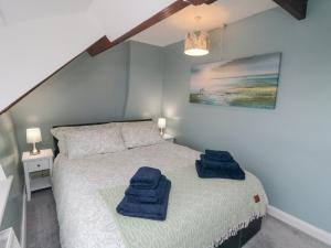 a bedroom with a bed with blue towels on it at Newton Cottage in Whitby