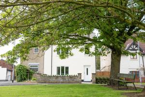 a bench in front of a white house at Stay Northside - Luxury Corporate & Holiday Stays, County Durham 