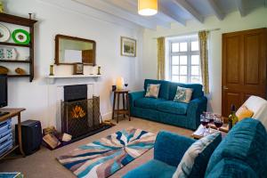 a living room with a blue couch and a fireplace at Garden Cottage Newcastle Emlyn in Newcastle Emlyn