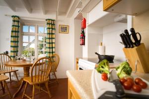 a kitchen with a table and a counter with vegetables on it at Garden Cottage Newcastle Emlyn in Newcastle Emlyn