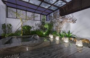 uma banheira de hidromassagem exterior num jardim com luzes em Domo Hotel em Taichung