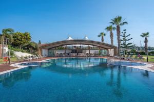 a large swimming pool in front of a building at Sisus Marina Hotel in Cesme