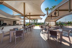 a restaurant with tables and chairs with a view at Sisus Marina Hotel in Çeşme