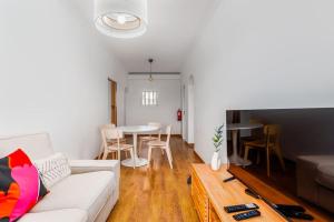 a living room with a couch and a table at Bright and Spacious Two Bedroom Apt in Almada in Almada