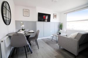 a living room with a table and a couch at Entire 2 Bed Modern Flat with Parking For Families, Business and Contractors in Bristol
