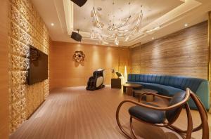 een wachtkamer met een blauwe bank en stoelen bij Domo Hotel in Taichung