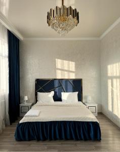 塔爾迪庫爾干的住宿－Гостиничный комплекс Paradise，一间卧室配有一张大床和一个吊灯。