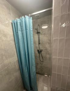 y baño con ducha con cortinas azules. en VISTA Apartment en Mińsk Mazowiecki