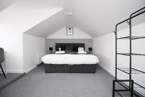 Un dormitorio con una gran cama blanca y una escalera en Entire 2 Bed Modern Flat with Parking For Families, Business and Contractors en Bristol