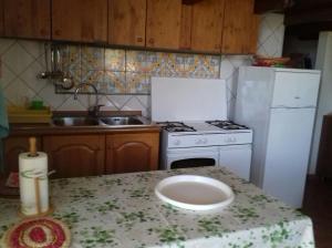 a kitchen with a white stove and a sink at La dimora del sole in Teulada