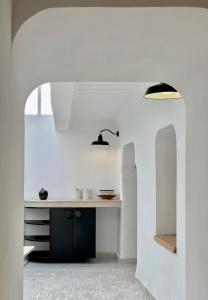 eine Küche mit weißen Wänden und einer Theke mit einer Spüle in der Unterkunft Riad de l'Ô with Pool, Rooftop, Free Breakfast in Marrakesch