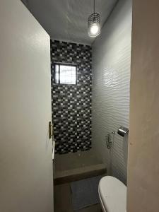 uma casa de banho com um chuveiro, um WC e uma janela. em House in Coron-The Grey House em Coron