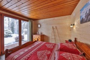 ein Schlafzimmer mit einem Bett und einem großen Fenster in der Unterkunft Chalet au bois des écureuils classé trois étoiles. in Muhlbach-sur-Munster