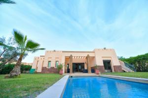 une maison avec une piscine en face de celle-ci dans l'établissement VILLA APPLE GARDEN RESORTS 45 MARRAKECH, à Marrakech