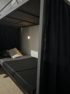 a bedroom with a bunk bed with a black mattress at House in Coron-The Grey House in Coron