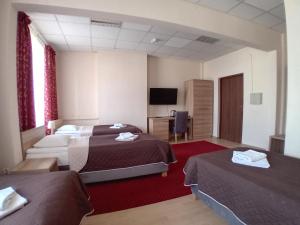 a hotel room with two beds and a flat screen tv at SCSK Żurawia in Warsaw
